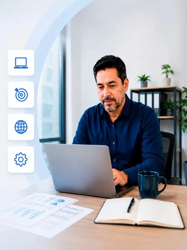 Empresario trabajando con un portátil en su oficina junto a iconos que representan servicios y capacidades digitales.